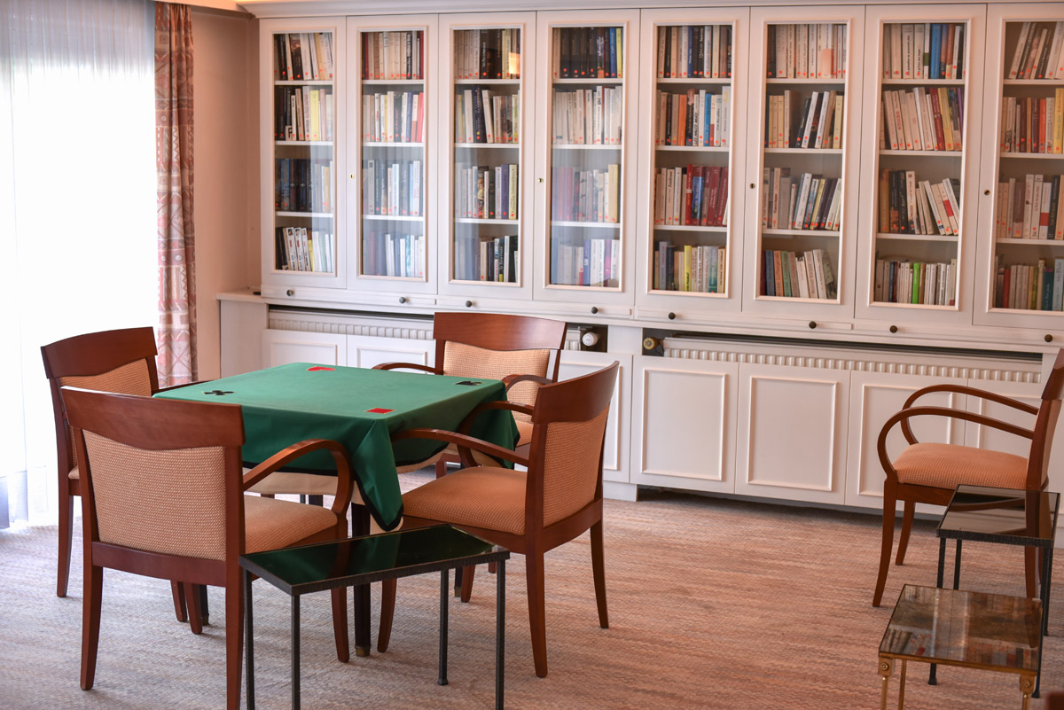 Bibliothèque et table de jeux dans un salon de la résidence
