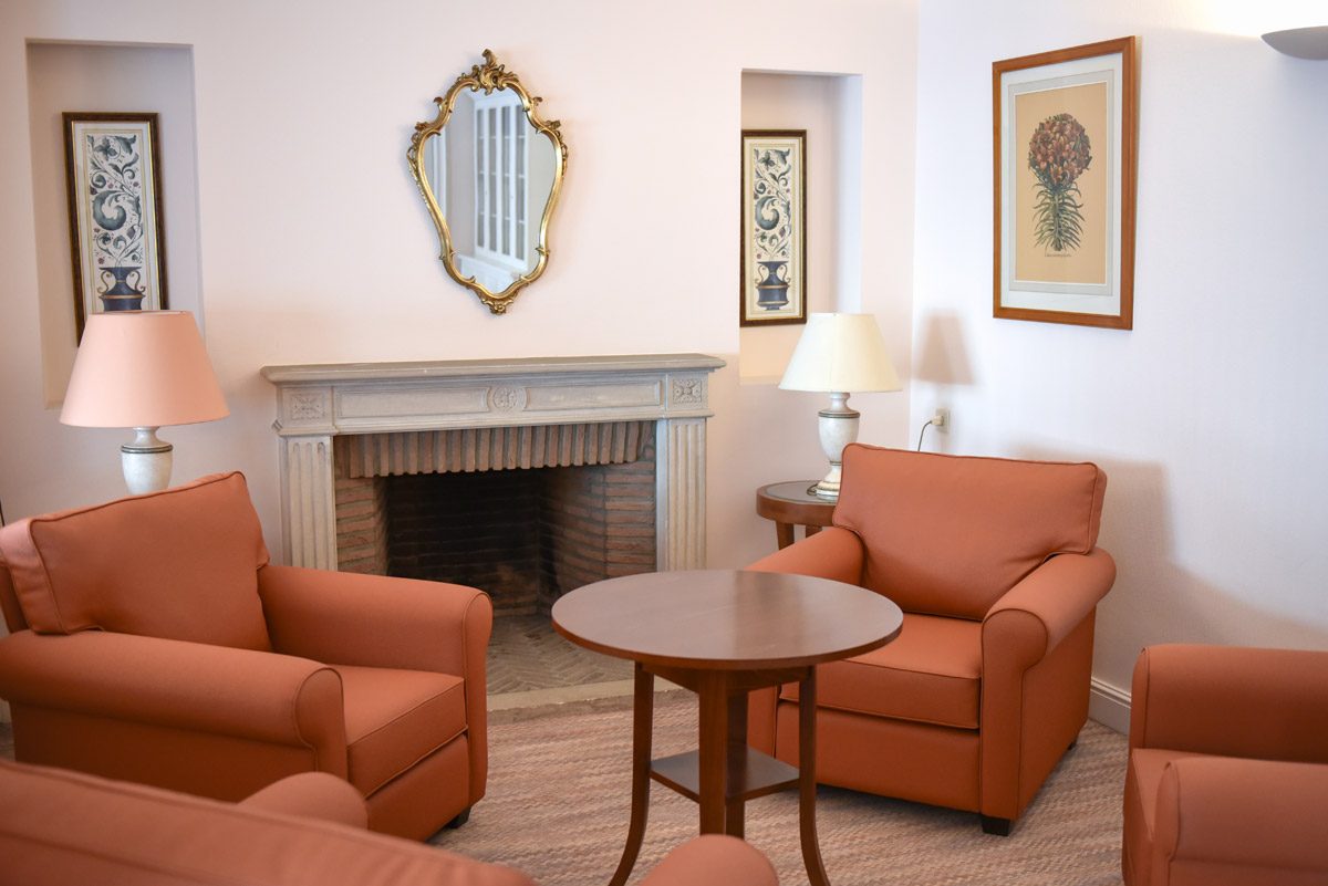 Salon de la résidence avec fauteuils et cheminée